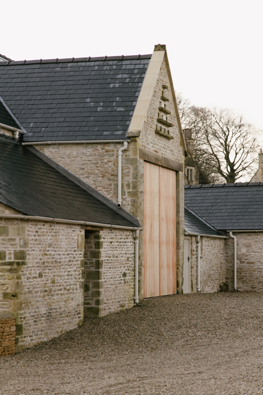 Exterior view of restored listed farm building with barn doors