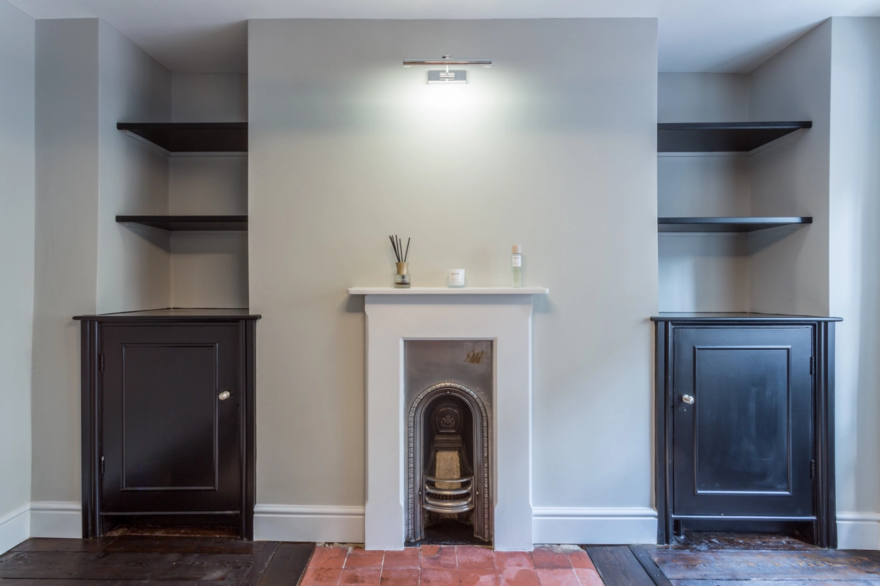 Interior view of renovated fireplace, alcove shelves and cupboards