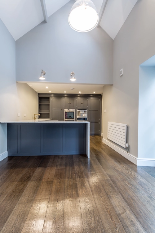 Full height interior view of the kitchen showing renovated wooden floor