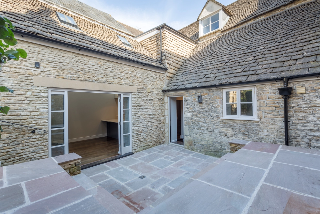 Exterior view of the stepped outdoor space, showing doors and renovated tile roof