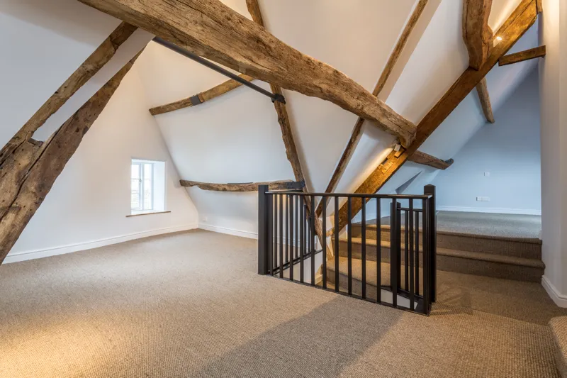 Interior view of top floor, showing exposed beams and staircase